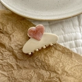 Detail view of heart-shaped marble acetate hair claw clip on cream base - Pink & Beige