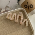 Detail of elegant wavy acetate hair claw clip with pearlescent texture and gold metal base - Floral Pink
