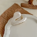 Detalle de pinza para el pelo elegante en acetato perlado con resorte dorado en plato cerámico - Blanco