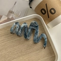 Macro view of wave-shaped acetic acid hair claw clip with blue marble ink texture - Aqua