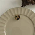 Detailed view of flower shaped tortoise shell hair claw clip on a ceramic tray - Flower