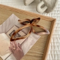 Macro detail of tortoiseshell butterfly hair claw clip on a stylish wooden tray - Marble Brown