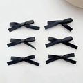 Détail de six nœuds à cheveux en ruban de satin noir alignés sur fond blanc neutre - Noir (Lot de 6)