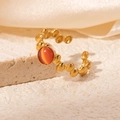 Detail of vintage 18K gold-plated ring with orange gemstone on textured stone surface - Orange Stone Style (R0808)