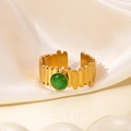 Detail van een vintage 18K vergulde titanium ring met groene edelsteen op crèmekleurige zijde - Groene Kattenoog Steen Stijl (R0849)