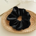 Detalle de coletero de terciopelo negro con textura acanalada en bandeja de mimbre - Negro Terciopelo