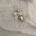 Dettaglio di un fermaglio per capelli in velluto crema con perla dorata - Stile Fiocco Con Perle