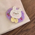 Close-up of handmade crochet rabbit hair clip with purple base and cherry accents - Purple Rabbit