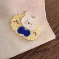 Detailed view of handmade crocheted bear clip with cherry embroidery and blue bow - Yellow Rabbit