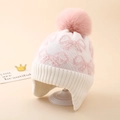 Detail of knit earflap hat showing bow jacquard pattern and soft pink pompom ball - One Size (3-8Y) / White