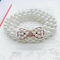 Elegant multi-layer white pearl elastic belt with a golden rhinestone bow buckle - Figure Eight Pearl Gold