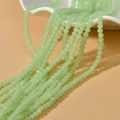 Pale green faceted rondelle beads 4mm for DIY jewelry making displayed on a ceramic plate - Opal Mint Green