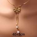 Elegante collana con fiocco dorato con perle bianche e catena a serpente su modella - Stile Perla e Fiocco