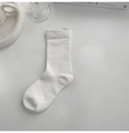 Minimalistische weiße Baumwollsocke für Damen flach auf einem weißen Schreibtisch liegend - Weiß