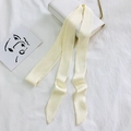 Pale yellow silk scarf tied on a white chain bag handle with a minimalist art card - 200cm / Cream
