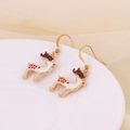 Détail de boucles d'oreilles de Noël renne avec émail blanc et crochets dorés sur plat - Renne Mignon Blanc