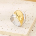 Detailansicht eines zweifarbigen Edelstahlrings auf einem natürlichen Steinsockel - US 6 / Gold und Silber