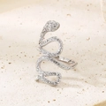 Gros plan d'une bague serpent argentée sertie de cristaux sur fond de pierre beige - US 6 / Couleur Acier (KR111733-GC)