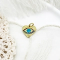 Detail of heart evil eye charm with colorful rhinestones on a golden base and white feathers - Heart Evil Eye