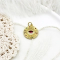 Macro-opname van evil eye hanger met rode steen op witte veren achtergrond - Rode Zirkonia Ronde Schijf 18,5*15,6mm