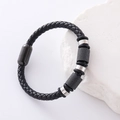Pulsera de hombre en cuero trenzado negro con cuentas de acero inoxidable sobre fondo piedra - Negro