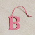 Detail shot of a pink leather B-shaped bag charm with a textured pebble finish - Letter B Pink