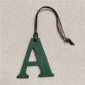 Detailansicht dunkelgrüner Lederanhänger Buchstabe A mit schwarzem Lanyard auf Leinen - Buchstabe A Dunkelgrün