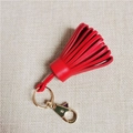 Detail showing high-quality red leather tassels with a golden metal clasp and ring - Red