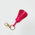 Detailed view of a bright fuchsia leather tassel keychain with gold-toned metal hardware - Rose Red