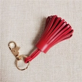 Detailed view of red leather tassel keychain with gold-tone spring clasp and ring - Burgundy