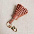 Close-up of caramel sheepskin leather tassel charm with gold lobster clasp for bags - Brown