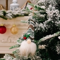 Gnomo di Natale appeso con cappello in maglia verde e agrifoglio su un albero innevato - Stile A (Cappello con Motivo Verde Bianco Marrone)