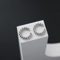 Dettaglio di orecchini a clip a C in argento con perline su supporto geometrico - Un Paio / Argento
