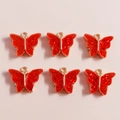 Detail of red glitter butterfly charms with gold metal base for DIY jewelry making - Red