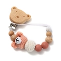 Close-up of crochet bear and silicone beads on a wooden baby pacifier clip chain - Pink