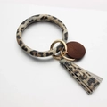 Leopard print leather keychain bracelet with wooden tag and matching tassel on white backdrop - Yellow Leopard