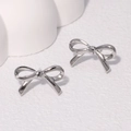 Minimalist polished silver bow knot stud earrings on a clean white textured background - Steel