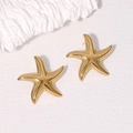 Golden starfish stud earrings in stainless steel on a white textured background - Gold