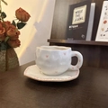 Macro shot of handmade ceramic coffee cup with pink hearts and a wavy matching saucer - Brown Edge Little Heart