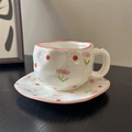Macro view of handmade ceramic coffee cup with hand-painted floral pattern and wavy edges - Pink Flower