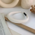Close-up of a thick white sponge headband with a black handmade label on the inner side - White