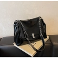 Detail of glossy black oil wax leather texture with silver chain strap and metal clasp - Black