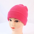 Close-up of bright pink knitted beanie featuring fine ribbed texture and classic cuff design - One Size / Hot Pink