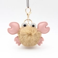Close-up of cute beige plush crab keychain with pink PU leather claws and golden clasp - Khaki
