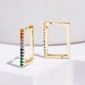 Close-up of golden rectangular hoop earrings with colorful zircon gemstones - Gold