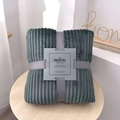 Detail of grey striped flannel blanket neatly folded with ribbon bow on wood table - 70x100cm / Premium Grey