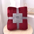 Detail of dark red flannel blanket with ribbed texture and grey ribbon gift packaging - Blooming Red