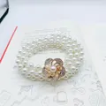 Elegant triple-layer pearl chain belt with a sparkling gold rhinestone floral buckle - Rose Bud Gold