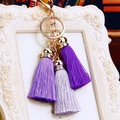Detail of purple silk tassels with gold metal ring and clasp on decorative background - Three Ice Silk Tassels / Purple Gradient