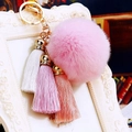 Close-up of pink faux fur pompom with colorful cotton tassels and golden alloy metal ring - Pink